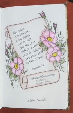 an open book with flowers on it and a poem written in the middle, sitting on a table