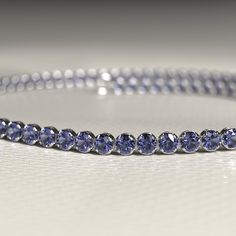 Add a breathtaking touch to your ensemble with this exquisite Tanzanite Tennis Bracelet. Skillfully handcrafted using high-quality 14K/18K gold, this custom stacking bracelet is perfect for everyday wear or special occasions. Adorned with stunning Tanzanite gemstones, this December birthstone bracelet is a must-have for any jewelry lover. It also makes a thoughtful Christmas gift that will surely impress. Don't miss out on our exclusive Cyber Sale and treat yourself or a loved one today!𝐅𝐞𝐚𝐭 Formal Adjustable Crystal Gemstone Bracelet, Fine Jewelry Round Tennis Bracelet For Party, Fine Jewelry Tanzanite Bracelets For Gift, Evening Diamond Bracelet, Formal Gold Bracelet With Sparkling Stones, Adjustable Single Strand Bracelet For Formal Occasions, Formal Round Crystal Bracelet With Prong Setting, Dazzling Gemstone Round Bracelet, Dazzling Gemstone Bracelet