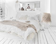 a bedroom with white walls and wooden floors