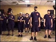 a group of men standing next to each other in front of a crowd wearing black uniforms