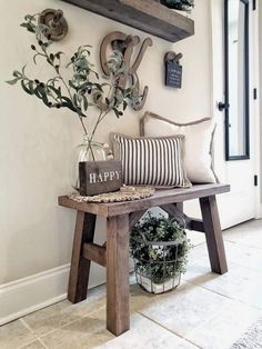 a wooden bench sitting in front of a wall with a plant on top of it