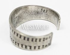 This beautiful Viking bracelet is historically accurate and modeled after a silver Viking bracelet found in the Curedale hoard at Lancashire, England in 1840. This type of stamped design was common in Viking culture, and solid silver bracelets such as this would have been used both as bullion and as jewelry. This particular bracelet we offer has been handmade of finely polished silver pewter and recreated from the archaeological find in every detail. The metal of this bracelet is completely safe Hand Forged Medieval Silver Jewelry, Hand Forged Silver Medieval Jewelry, Medieval Style Engraved Antique Silver Jewelry, Medieval Style Adjustable Engraved Jewelry, Antique Silver Medieval Jewelry With Oxidized Finish, Medieval Jewelry In Antique Silver With Oxidized Finish, Hand Forged Silver Viking Jewelry, Viking Style Silver Bangle Bracelet, Silver Viking Bracelet Engraved