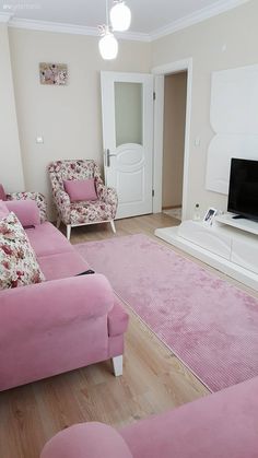 a living room filled with pink furniture and a flat screen tv