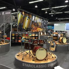 a drum set on display in a showroom with an advertisement for tama's