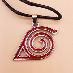 Unleash the spirit of the Shinobi with our Uzumaki Symbol Red Spiral Charm Necklace. This intricately designed accessory features the iconic red spiral and arrow emblem, a powerful symbol representing the Shinobi of Konoha and the enduring bonds of friendship. Crafted with meticulous detail, this necklace embodies the essence of resilience, unity, and camaraderie found within the Naruto universe. Whether for cosplay or everyday wear, this necklace serves as a tribute to the unwavering strength a Red Spiral Jewelry As Gift, Red Spiral Jewelry For Gifts, Spiral Shaped Red Jewelry For Gifts, Symbolic Red Pendant Necklace, Adjustable Red Spiral Jewelry, Red Themed Necklace For Gift, Themed Red Necklace For Gifts, Themed Red Necklace For Gift, Uzumaki Symbol