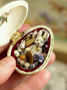 someone holding a small ring with tiny stuffed animals in it