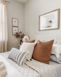 a white bed topped with lots of pillows