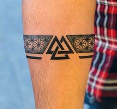 a man with a tattoo on his leg that has triangles and stars in the middle