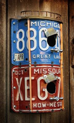 an old license plate hanging on the side of a wooden fence