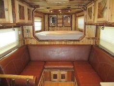 the inside of an rv with leather couches and wood paneling on the walls