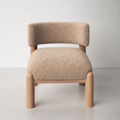 a beige chair sitting on top of a white floor