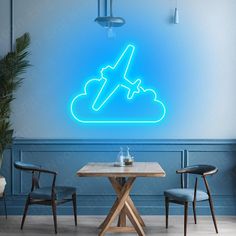 an airplane is flying through the sky on a neon blue wall above a table and chairs