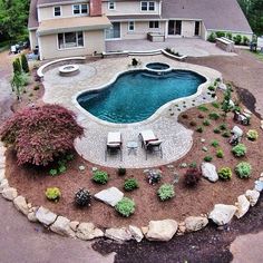 an aerial view of a backyard with a pool and patio furniture in the foreground