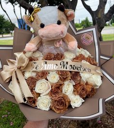 a teddy bear sitting on top of a bouquet of roses