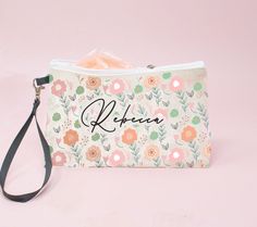 a personalized pouch with flowers and the name kleene on it is sitting on a pink surface