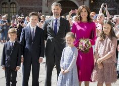 a group of people standing next to each other in front of a building filled with people