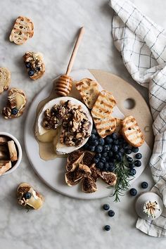 a white plate topped with blueberries and waffles next to other food items