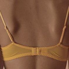 the back of a woman wearing a yellow bra