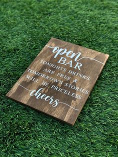 a wooden sign sitting on top of green grass