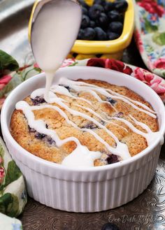 a blueberry cobbler is being drizzled with icing