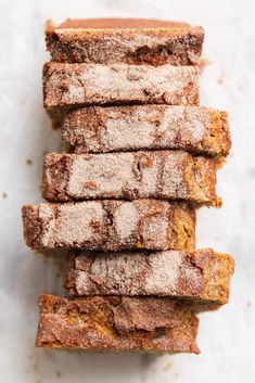 several pieces of bread with powdered sugar on top sitting next to each other in a pile