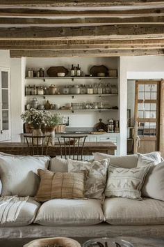 a living room filled with furniture and lots of pillows on top of a couch next to a table