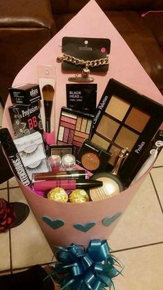 a pink box filled with lots of makeup and other items on top of a table