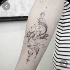 a woman's arm with a black and white tattoo design on the left forearm