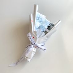 a bunch of rolled up papers tied to each other with ribbons around them on a white surface