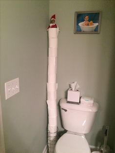 a white toilet sitting in a bathroom next to a roll of toilet paper on the wall