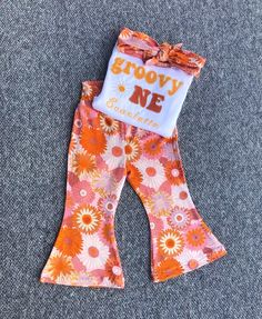 an orange and white flowered bell bottoms with the words groovy me on it