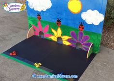 a child's play area made out of cardboard with ladybugs and flowers painted on it