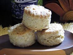 three biscuits stacked on top of each other on a plate next to a bottle of wine