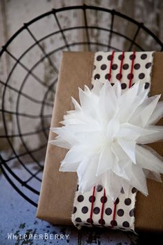 a present wrapped in brown paper with a white flower