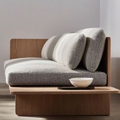 a couch with two pillows and a bowl on it