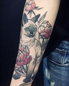 a cat and flowers tattoo on the arm