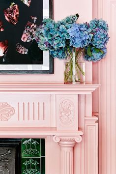 a pink fireplace mantel with blue hydrangeas