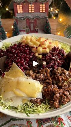 a white plate topped with lots of food on top of a table next to a christmas tree