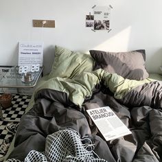 an unmade bed in a bedroom with black and white checkerboard flooring