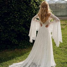 the back of a woman in a white wedding dress, with her hands on her hips