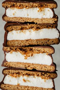 four pieces of cake sitting on top of each other with white and brown toppings