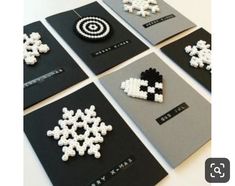 six snowflakes are arranged on black and gray cards with white bead designs