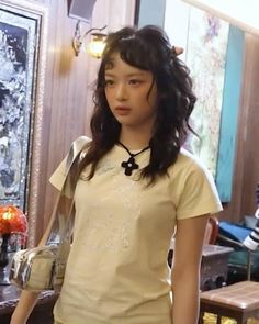 a young woman standing in front of a table