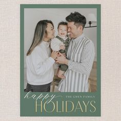 a holiday card with the words happy holidays and a photo of two people holding a baby