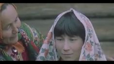 two women wearing headscarves and scarves are looking at each other in front of stairs