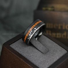 an engraved ring sits on top of a box