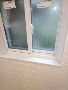 a bathroom window with two glass panes in it