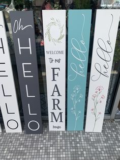 three wooden signs that say welcome to my farm and the other two are painted in different colors