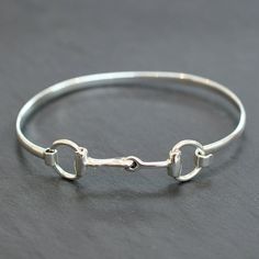 Silver bangle with a 'bit' clasp. Circa 2020. Weight:  10.9 grams Dimensions:  6.8 cm x 5.7 cm Each and every piece listed by Vintage Fine Jewellery has been restored by hand in our London workshop by highly skilled jewellers. Our jewellers use the same expertise to restore a piece of jewellery, as were used in their creation many years ago. If you would like to see more of the Vintage Fine Jewellery Collection, visit us at: www.vintagefinejewellery.com We ship all of our sales free of charge us Silver Horse, Vintage Fine Jewelry, The Bangles, Horse Bits, Silver Bangle, Fine Jewelry Collection, Fine Jewellery, Silver Bangles, Jewellery Collection