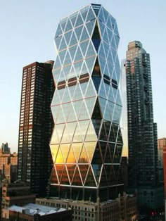 a very tall building in the middle of a city with many buildings around it and skyscrapers on both sides